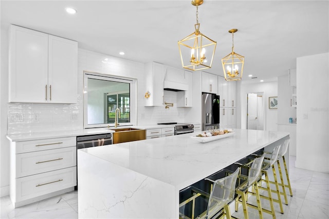 kitchen featuring backsplash, stainless steel appliances, white cabinets, and a kitchen island