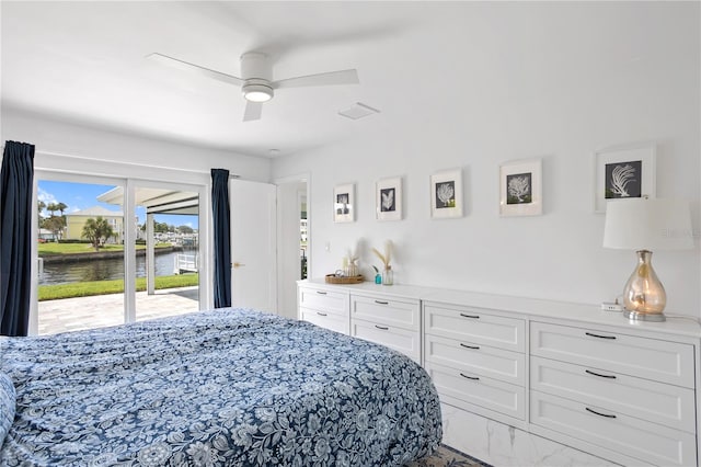 bedroom featuring ceiling fan, a water view, and access to exterior