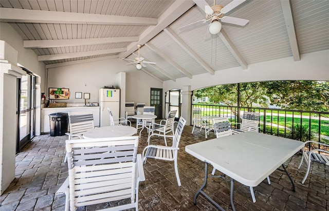 sunroom featuring ceiling fan and vaulted ceiling with beams