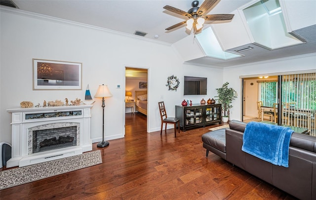 living room with ceiling fan, ornamental molding, a premium fireplace, and wood-type flooring