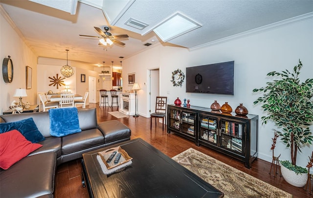 living room with dark hardwood / wood-style flooring, crown molding, and ceiling fan with notable chandelier