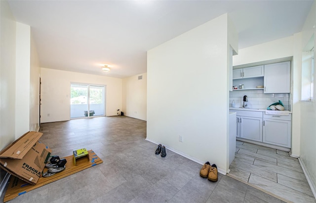 living room featuring sink and light tile patterned floors