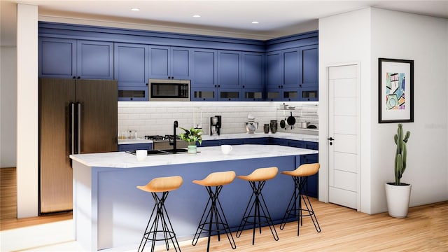 kitchen with blue cabinets, stainless steel microwave, decorative backsplash, and a kitchen bar