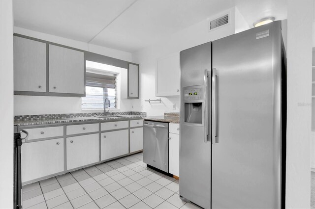 kitchen featuring stainless steel appliances, sink, and light tile patterned floors