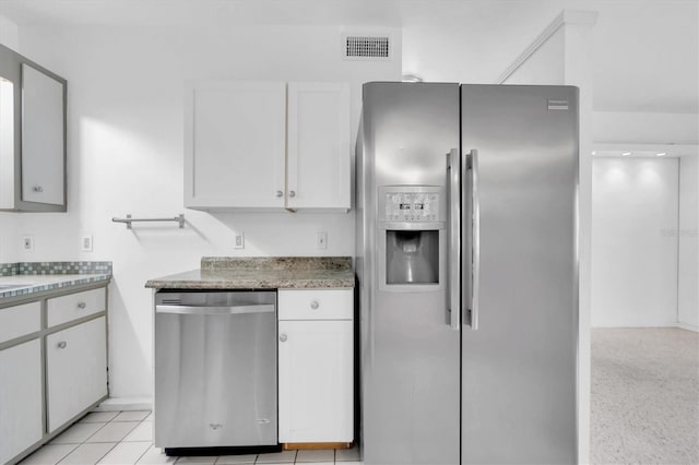 kitchen featuring appliances with stainless steel finishes, light tile patterned floors, and white cabinetry