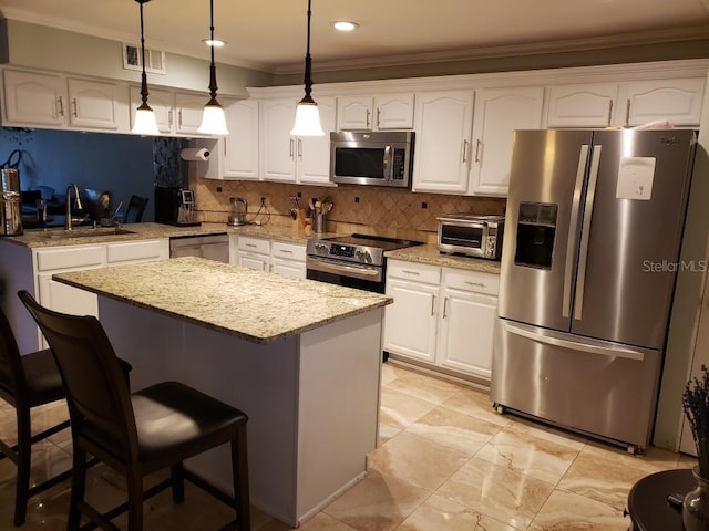 kitchen featuring backsplash, stainless steel appliances, white cabinets, and hanging light fixtures