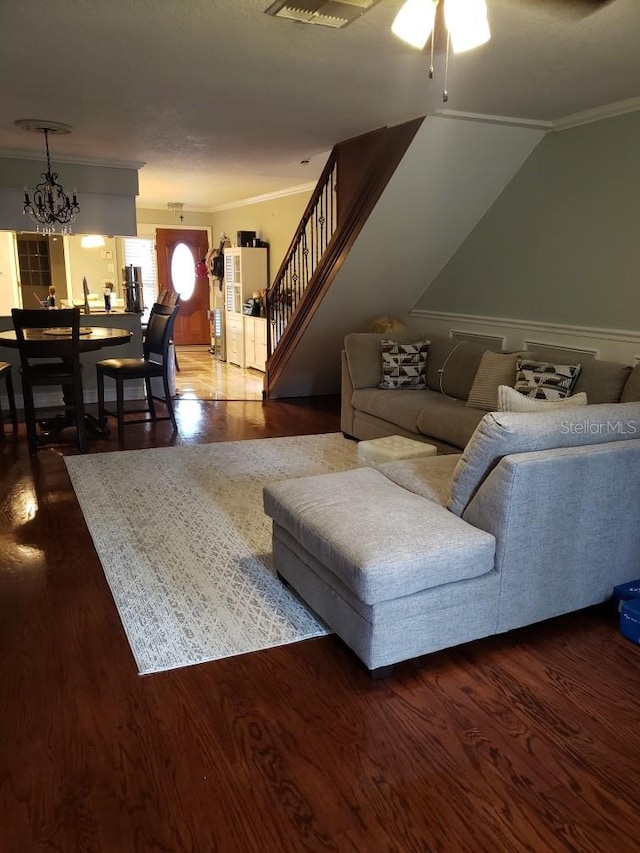 living room with ceiling fan with notable chandelier, vaulted ceiling, crown molding, and wood-type flooring