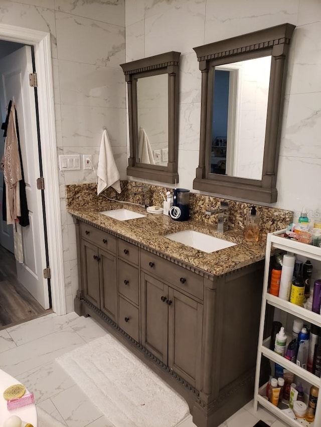 bathroom featuring tile walls, double vanity, and tile patterned floors