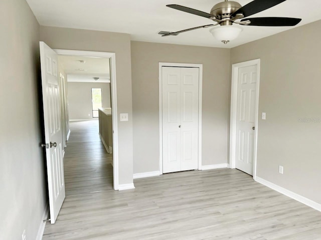 unfurnished bedroom featuring light wood-type flooring, baseboards, a closet, and ceiling fan