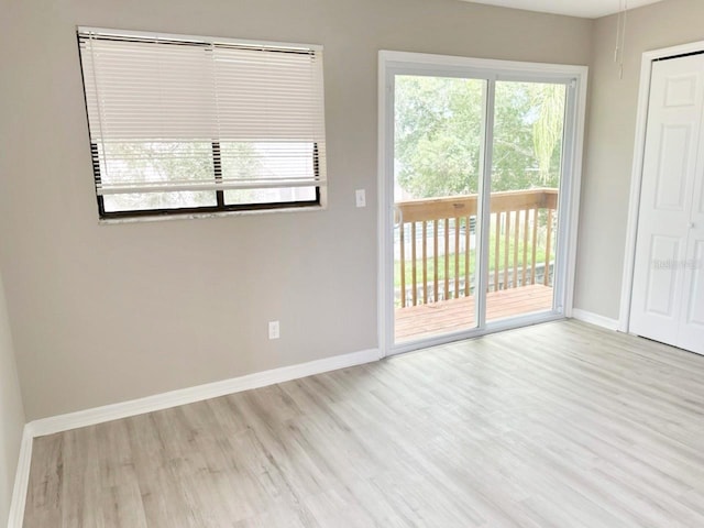 unfurnished room featuring baseboards and wood finished floors
