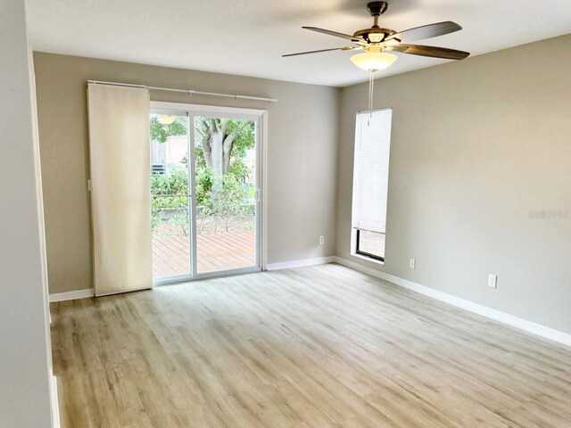 empty room featuring ceiling fan, plenty of natural light, and light hardwood / wood-style floors