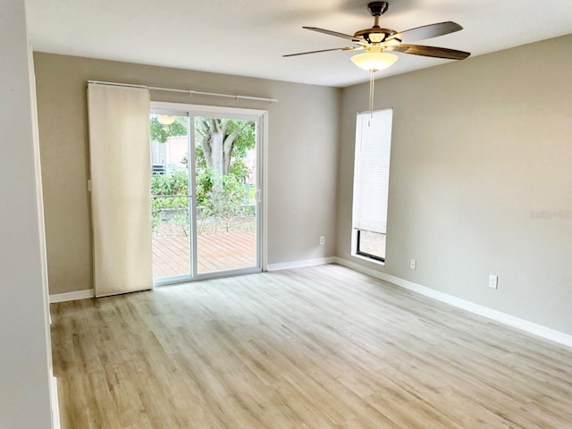 spare room with light wood finished floors, baseboards, and ceiling fan