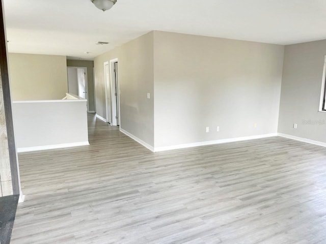 spare room featuring wood finished floors and baseboards