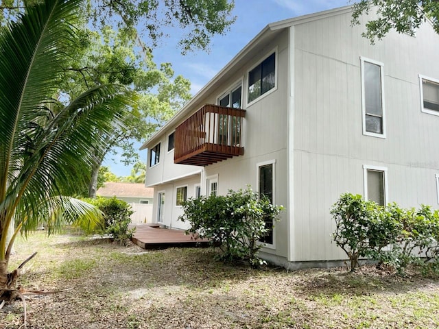 back of property featuring a balcony and a deck