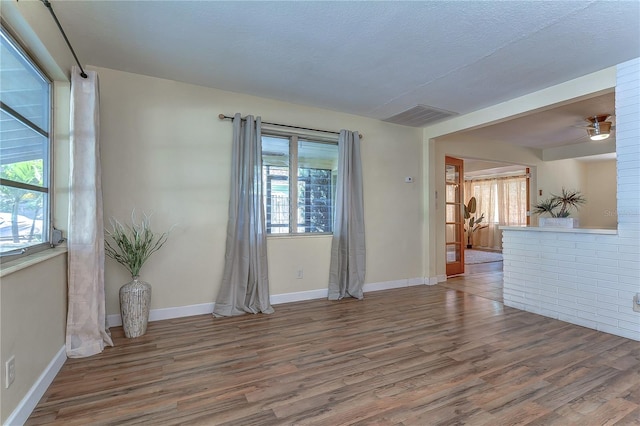 spare room featuring a textured ceiling, ceiling fan, and hardwood / wood-style floors