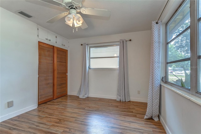 unfurnished bedroom with ceiling fan, light hardwood / wood-style floors, and a closet