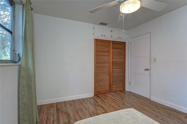 unfurnished bedroom with ceiling fan, a closet, and light hardwood / wood-style floors