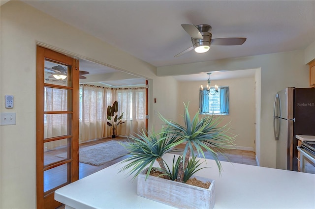 dining area featuring light hardwood / wood-style floors and ceiling fan with notable chandelier