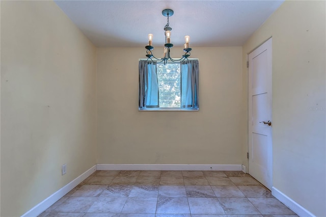 unfurnished room with a chandelier and light tile patterned floors