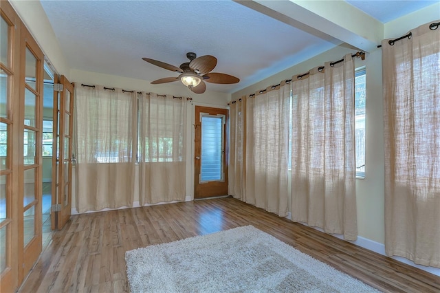 spare room featuring a textured ceiling, light hardwood / wood-style flooring, and ceiling fan