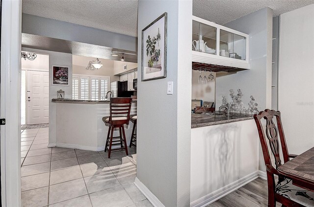 kitchen with fridge, tile patterned floors, and a textured ceiling