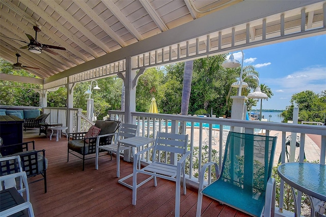 wooden terrace featuring ceiling fan and a water view