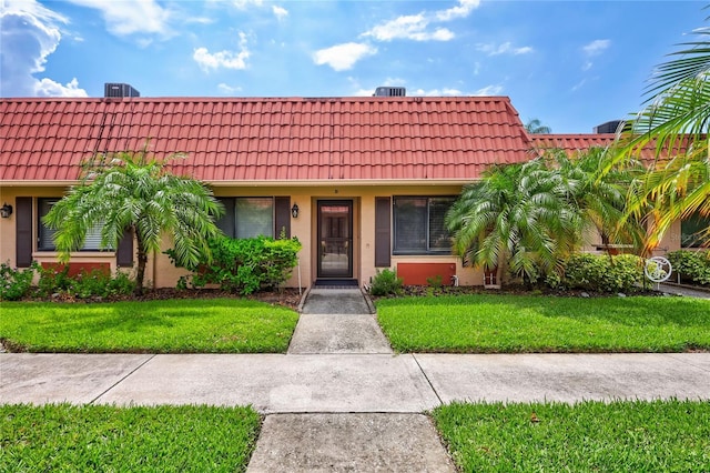 19029 US Highway 19 N Unit 12B, Clearwater, FL 33764 - view of front of home featuring a tiled roof, a front yard, and stucco siding