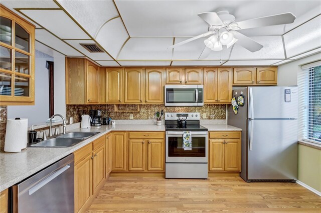 19029 US Highway 19 N Unit 12B, Clearwater, FL 33764 - kitchen with stainless steel appliances, a sink, light wood-style floors, and glass insert cabinets