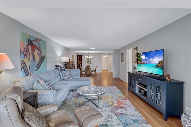 living room with an inviting chandelier and light hardwood / wood-style flooring