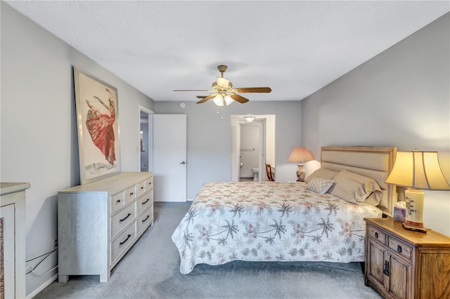 carpeted bedroom with ceiling fan and ensuite bath