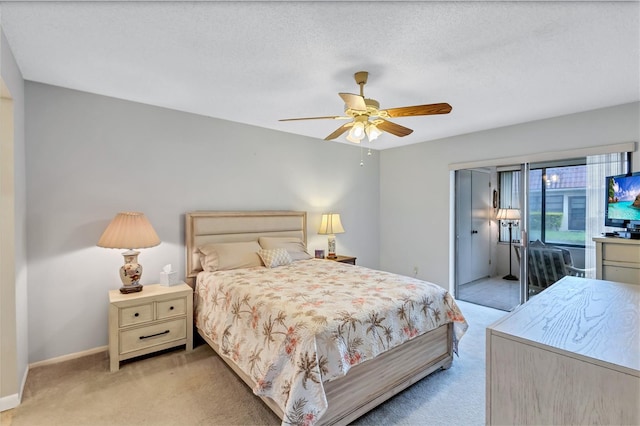 bedroom with ceiling fan, light carpet, and a textured ceiling