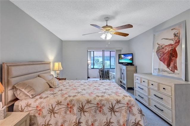 carpeted bedroom with ceiling fan and a textured ceiling