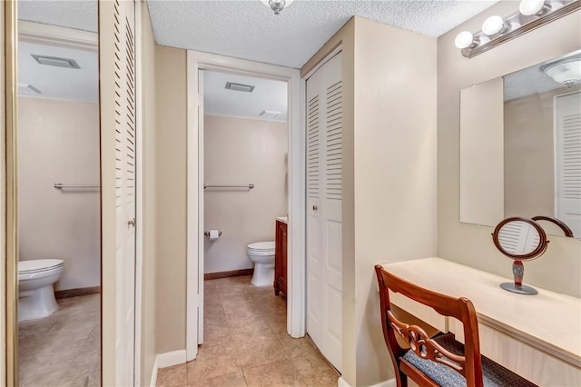 bathroom with tile patterned flooring, a textured ceiling, and toilet