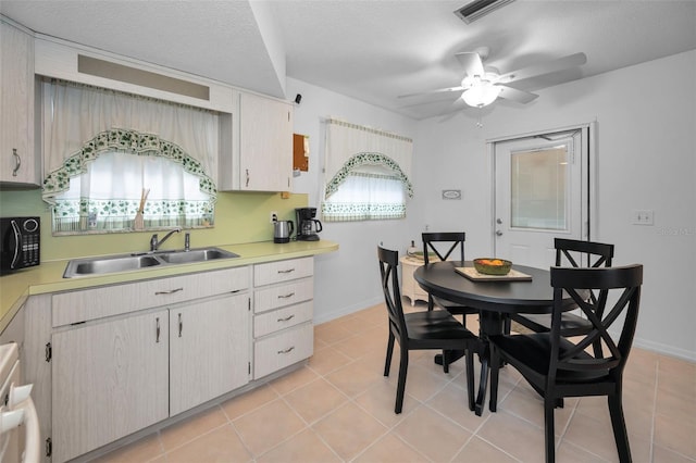 kitchen with a healthy amount of sunlight, light countertops, a sink, and visible vents