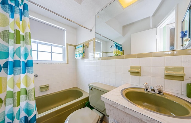 bathroom with tasteful backsplash, toilet, shower / bath combo with shower curtain, vanity, and tile walls