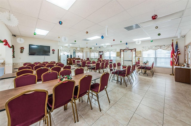 dining space with a drop ceiling and light tile patterned floors