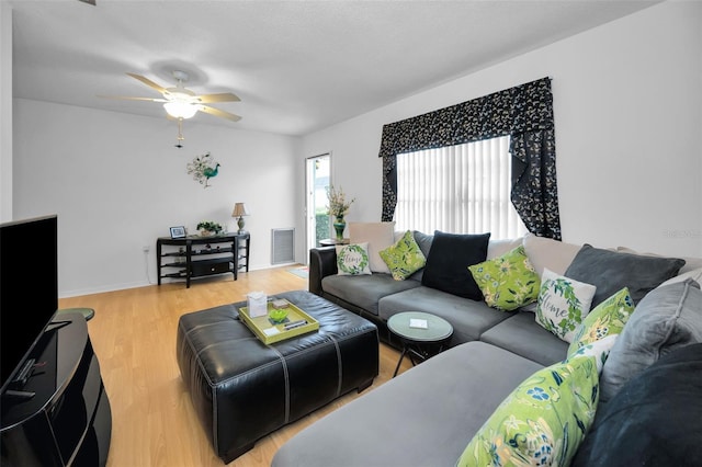 living room featuring ceiling fan, visible vents, and wood finished floors