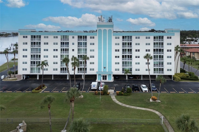 view of building exterior featuring uncovered parking and a water view