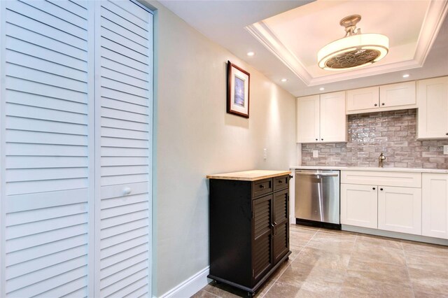 kitchen with dishwasher, a raised ceiling, and white cabinetry