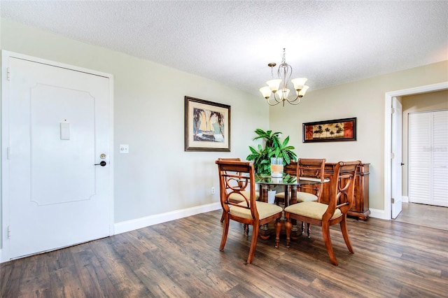 dining space featuring a textured ceiling, an inviting chandelier, and dark hardwood / wood-style floors