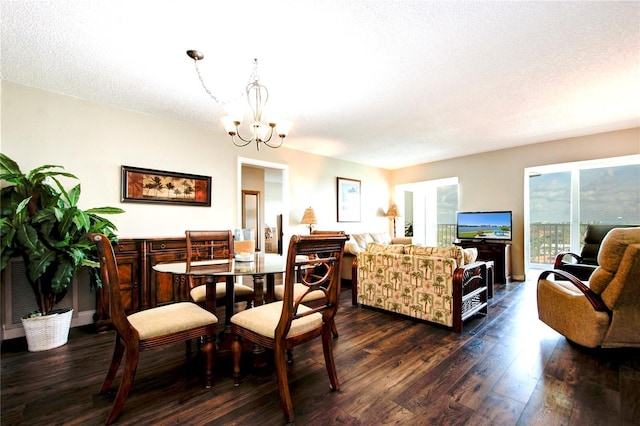 dining room with dark wood-style floors, a textured ceiling, and a notable chandelier