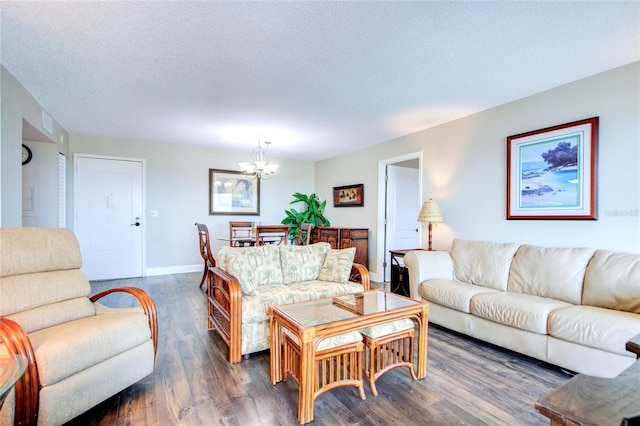 living area with a textured ceiling, baseboards, dark wood finished floors, and a notable chandelier