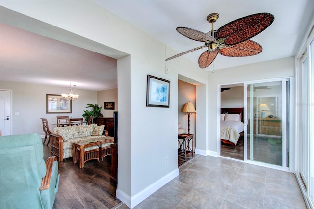 corridor featuring an inviting chandelier, baseboards, and wood finished floors