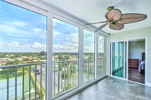 unfurnished sunroom featuring ceiling fan