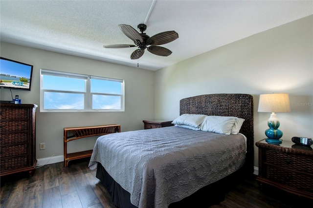 bedroom with dark wood-type flooring, a textured ceiling, and ceiling fan