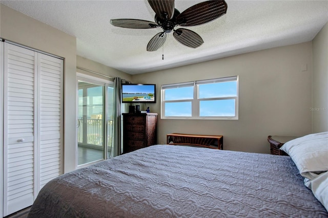 bedroom featuring access to exterior, multiple windows, and a textured ceiling