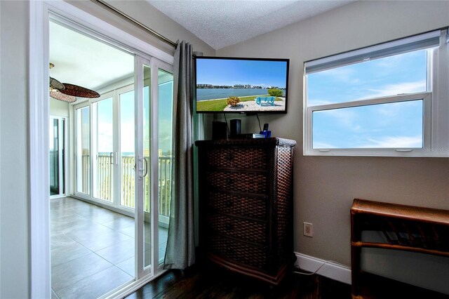 doorway to outside with a textured ceiling and wood-type flooring