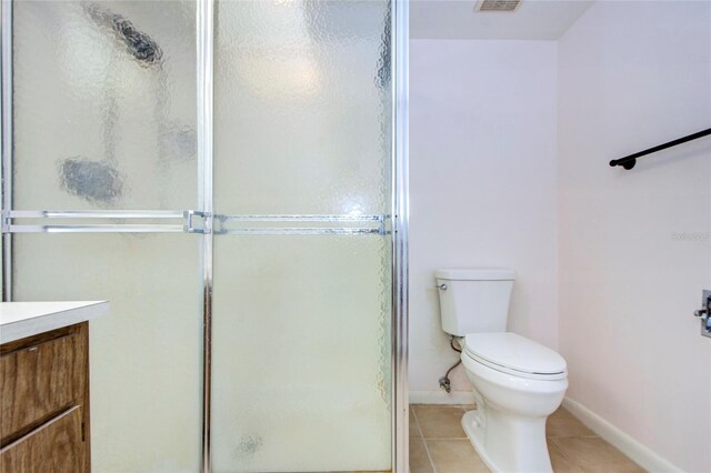 bathroom with tile patterned flooring, vanity, toilet, and an enclosed shower