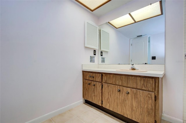 bathroom with baseboards, vanity, and tile patterned floors