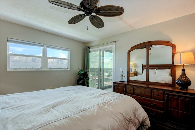 bedroom featuring ceiling fan, access to exterior, and a textured ceiling